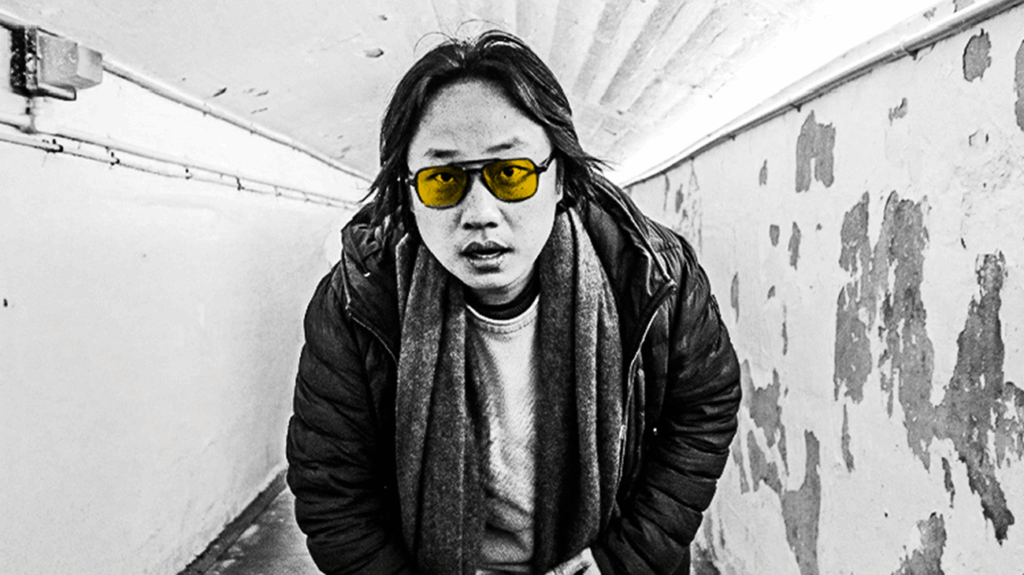 Jimmy O. Yang standing in an underground subway posing for the camera.