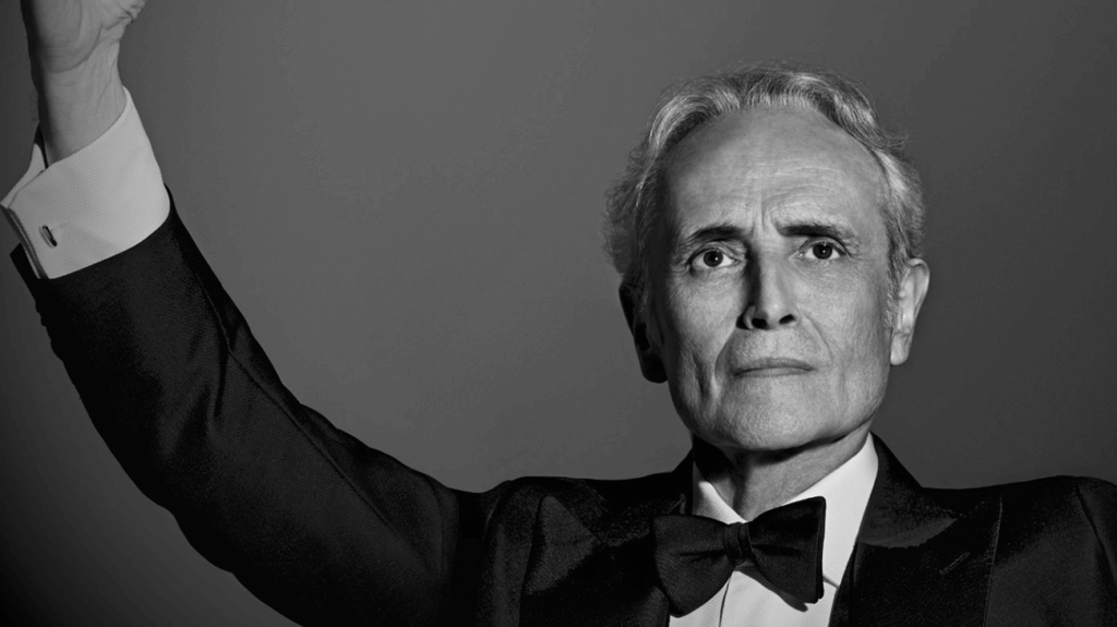 Black and white photo of Jose Carreras in a tuxedo, exuding elegance and sophistication.