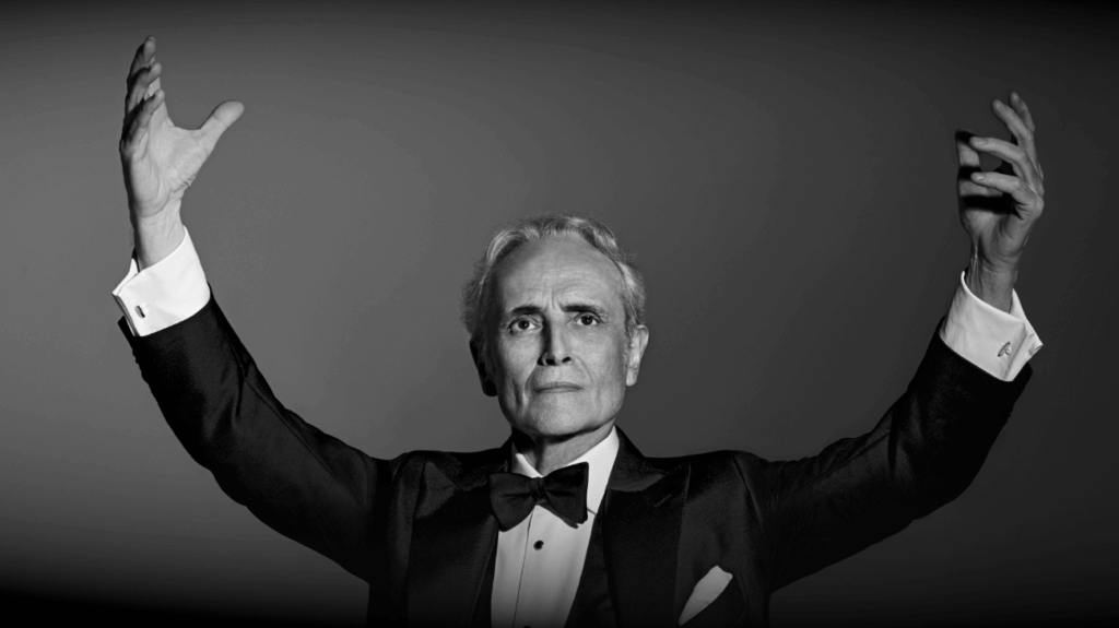 Black and white photo of Jose Carreras in a tuxedo, exuding elegance and sophistication.