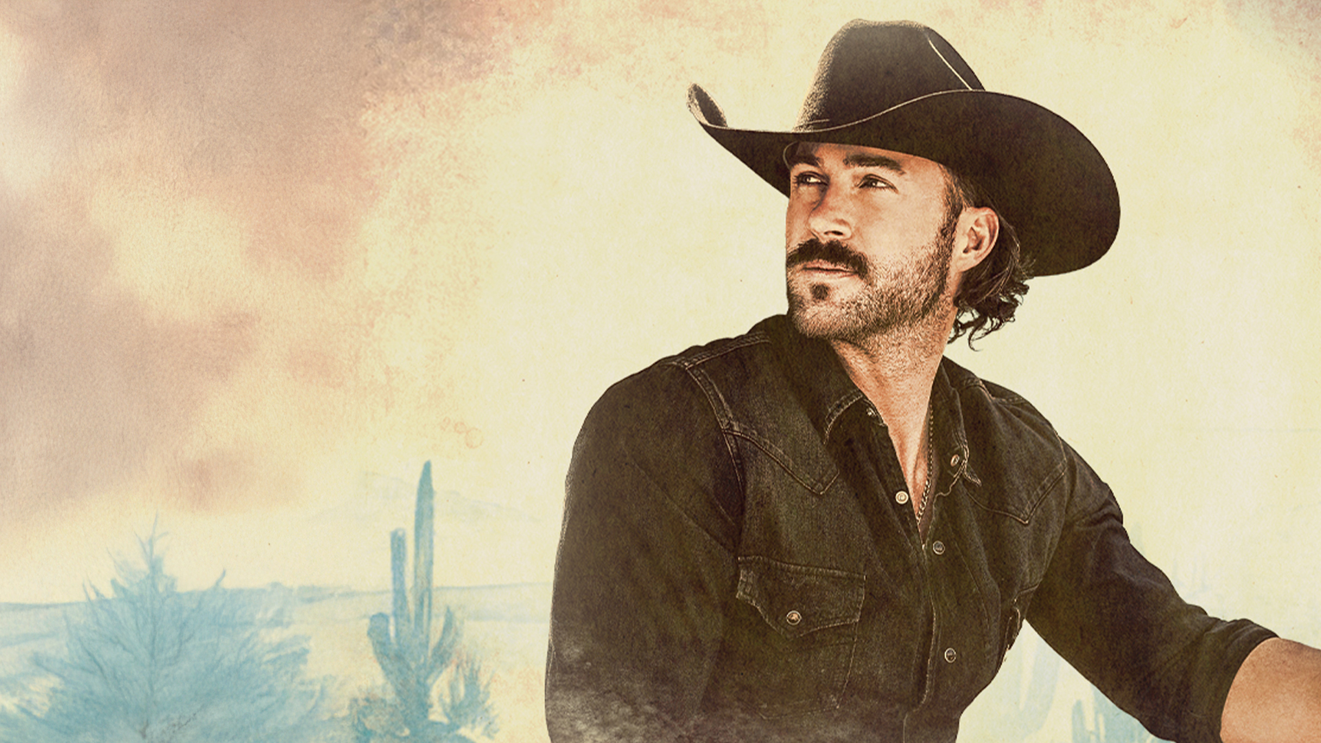 Singer Riley Green posing for the camera in a shirt and cowboy hat.