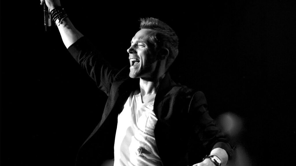 Ronan Keating revving up the crowd while performing on stage.