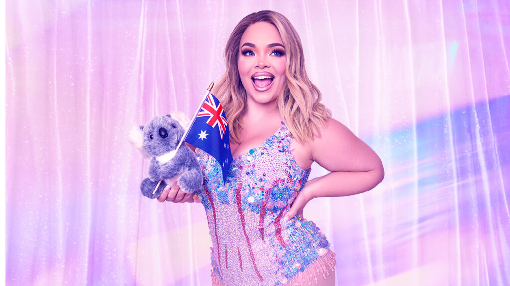Trisha Paytas blue bodysuit holds a koala and Australian flag, smiling at the camera.